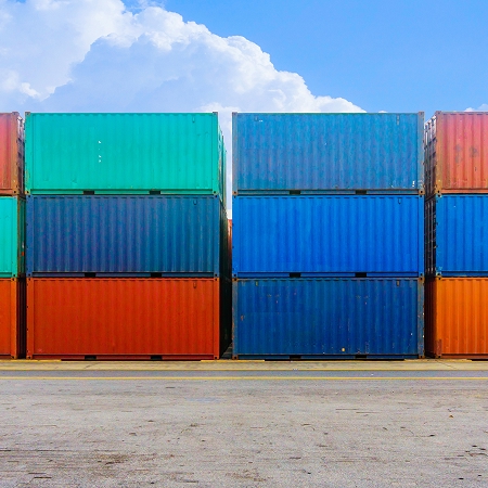 Conteneurs colorés empilés en plein air représentant les différentes étapes de transformation en espace habitable