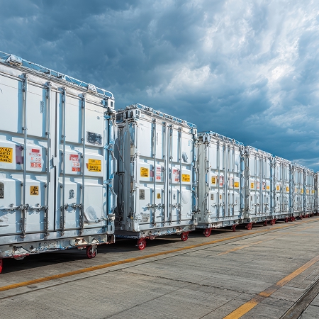 Rangée de conteneurs réfrigérés neufs alignés sur un quai pour illustrer la comparaison de coût entre neuf et usagé
